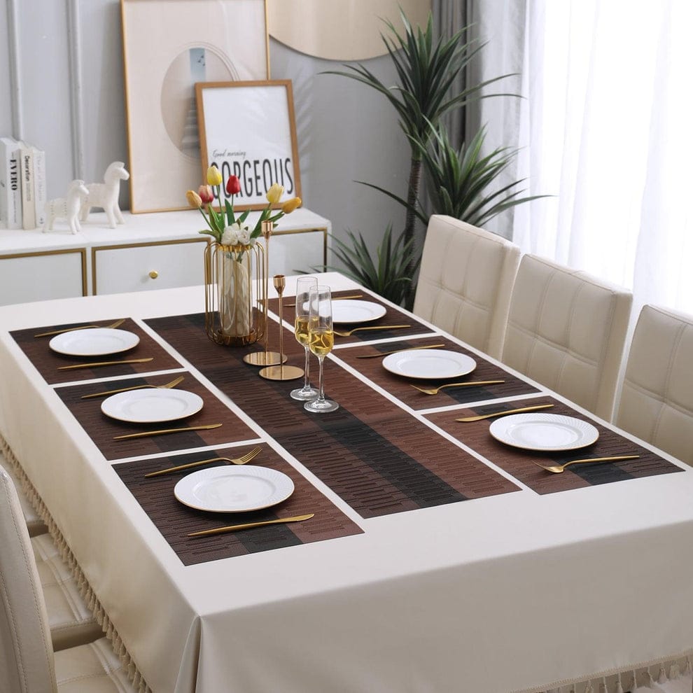 Dining table set with placemats, plates, and cutlery in a well-lit room.