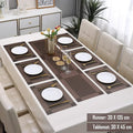 Dining table set with a runner and tablemat on a white table, surrounded by chairs.